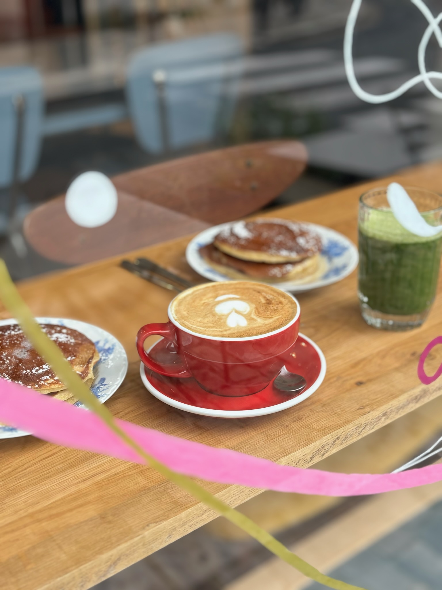 petit-déjeuner en vitrine : cappuccino, pancakes et jus détox dans un coffee shop cosy à Bourges